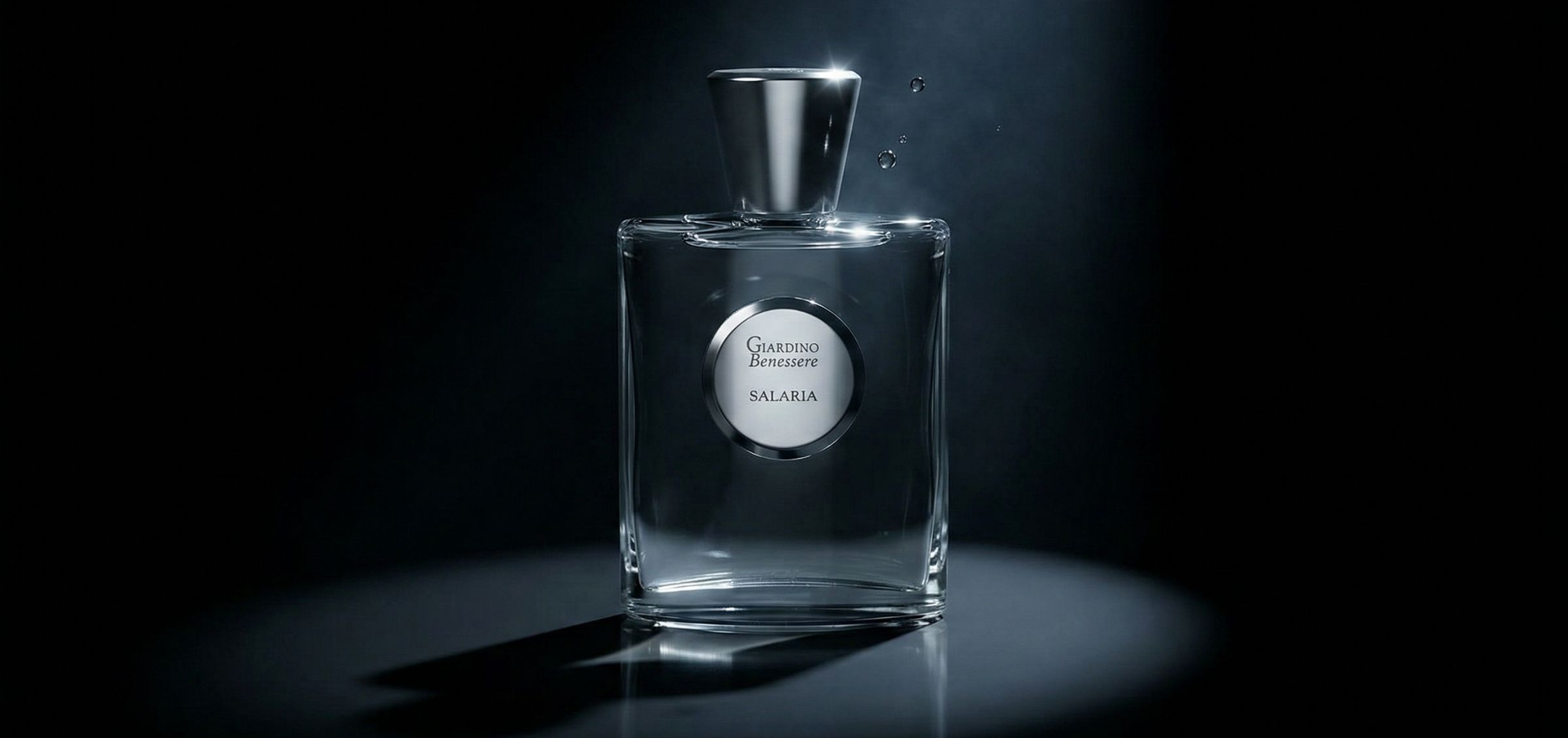 inpresioa-perfumy-giardino-banessere-salaria-jako-esencja-elegancji-i-balansu - Inpresioa Perfume bottle with round silver label reading Giardino Benessere Salaria, illuminated on a dark backdrop with a reflected base glow.