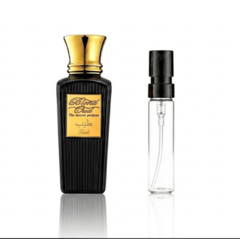 Black perfume bottle with a gold cap and gold label reading Blend Oud, next to a clear spray atomizer on a white background with a faint reflection below the bottles